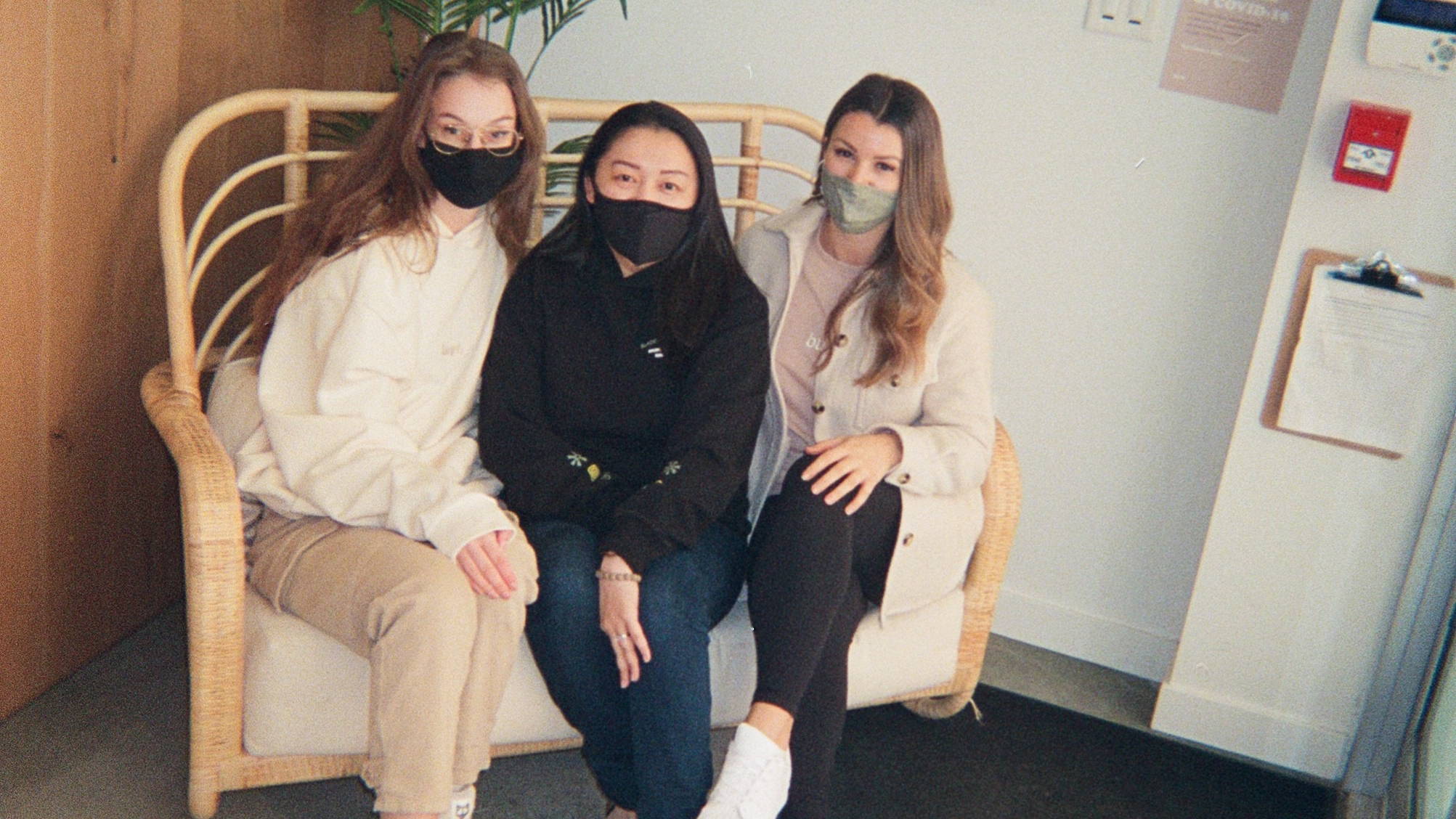 Three of our Burb team members sitting on a couch at our Broadway location.