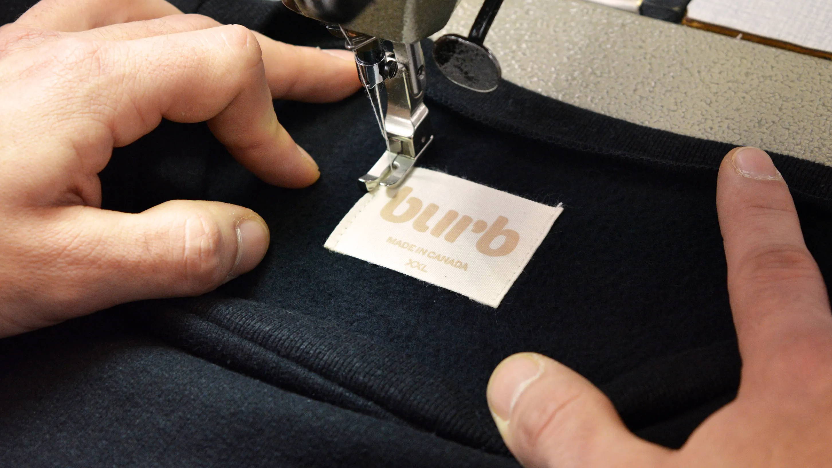 Burb logo stitched onto a Comfort Collection Crewneck.