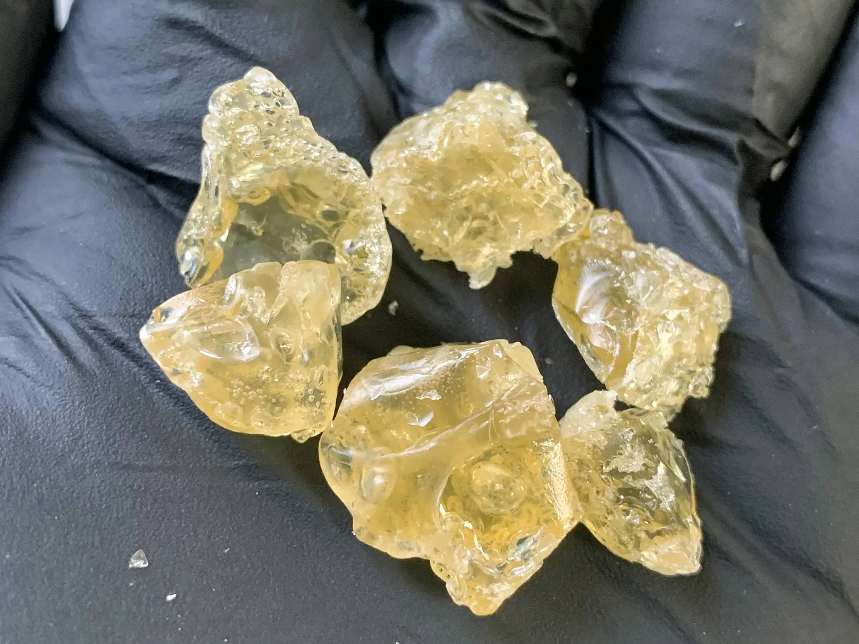 A photo of cannabis THCA diamonds in the palm of a hand.